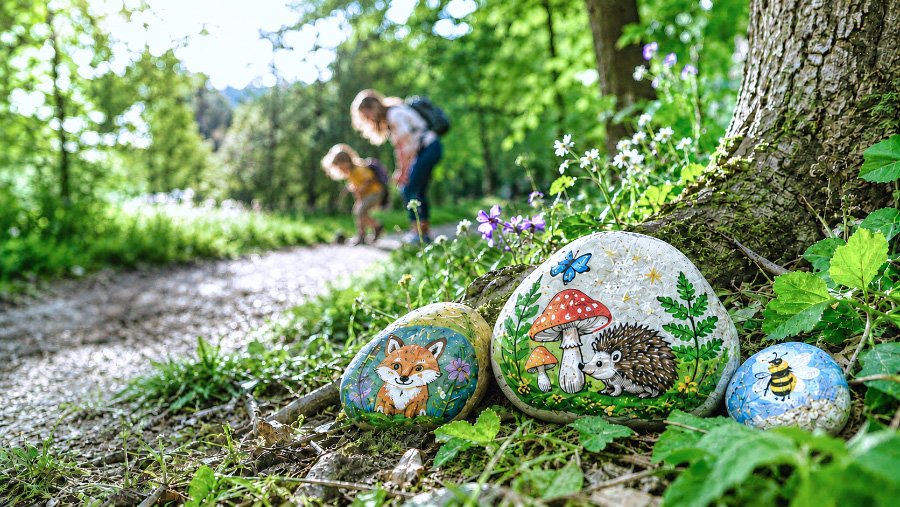 Child discovering a painted rock in a park
